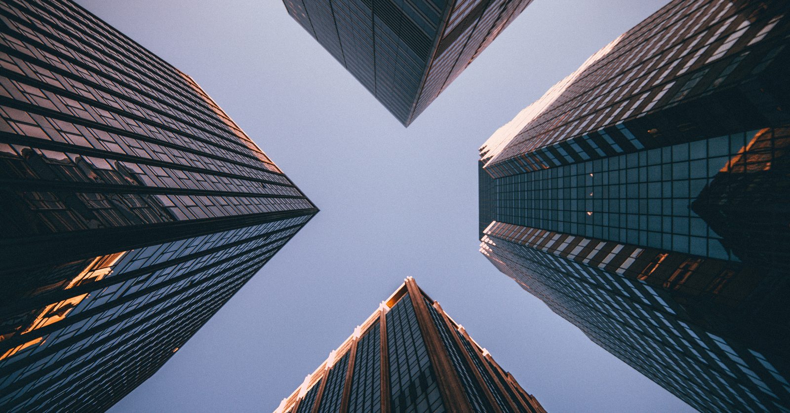 Corporate skyscrapers viewed from below, meeting in the sky